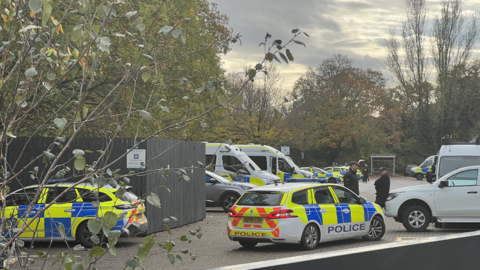 Police - there are two police cars and at least two police vans - parked in a car park close to the protest on Wednesday.