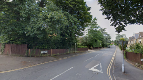 A road junction. The road has trees to the side of it and a road sign reading "Mount Harry Road".
