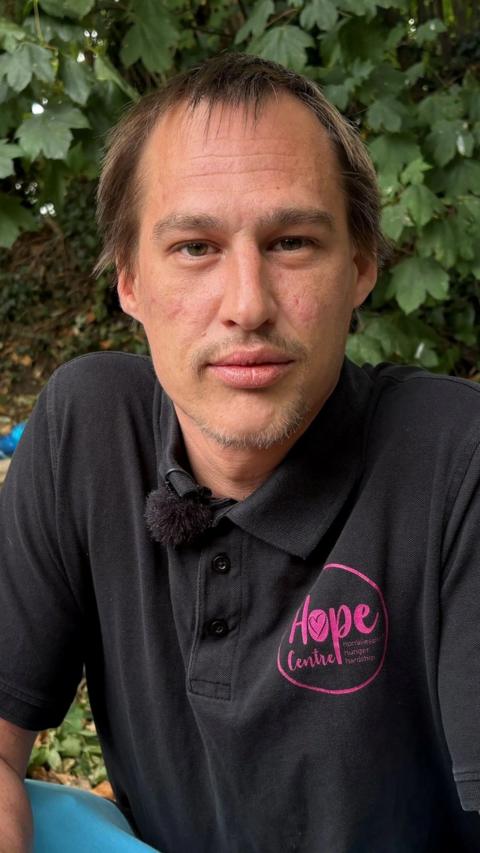 A man in a black top looking into the camera