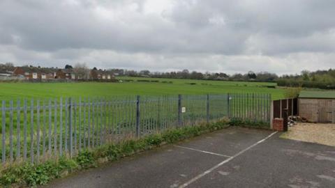 Open fields off Alfreton Road in Selston, fenced off with a car park at the front of the image.