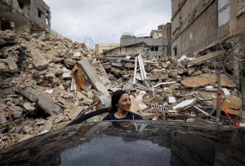 A woman stands outside her destroyed house in Lebanon