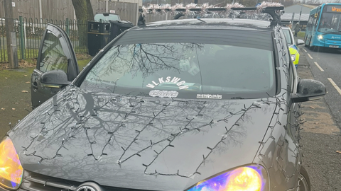 Close-up view of fairy lights taped to the car bonnet