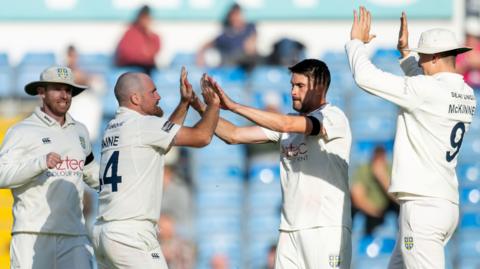 Ben Raine and Will Rhodes high-five each other as two other Durham players run in, including Ben McKinney on the right (McKinney 9 on his back) 