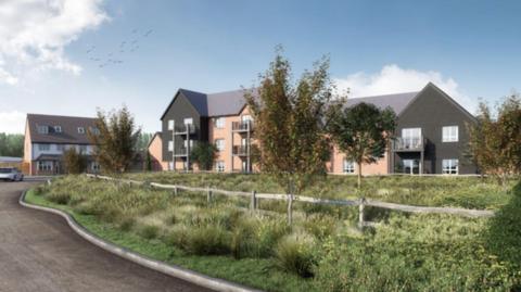 A development of new homes surround an area of grass and young trees

