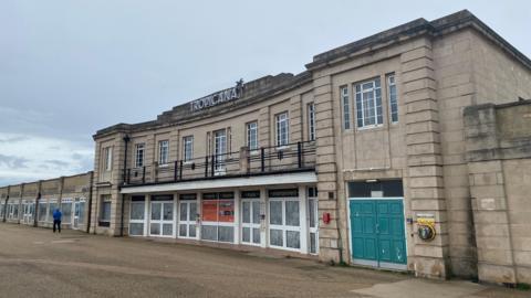 The Tropicana in Weston-super-Mare. There are several windows across the width of the beige building. There is a Tropicana sign at the top of the building.