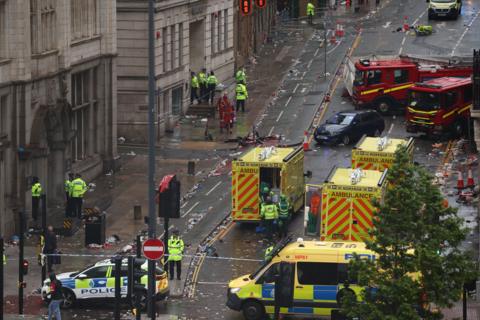 An aerial view of a street cordoned off by police, with ambulances, fire engines and uniformed police officers present.