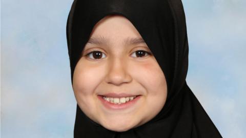 Sara Sharif wearing a hijab. She is smiling and looking directly at the camera. 