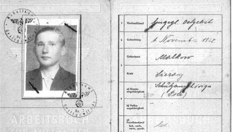 A black and white photocopy of a UK repatriation document where you can see Jozef Domanski as an older teenager. He has slicked back hair and is clean shaven while wearing a black jacket and white unbuttoned shirt.