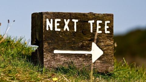 A sign pointing to the 'next tee' on a golf course