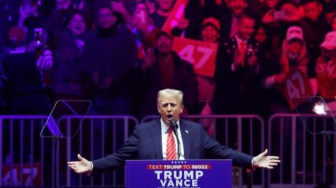 Donald Trump speaks before supporters on stage 