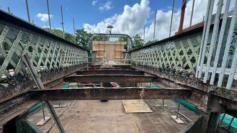 Vauxhall Bridge in Bristol. The two sides of the bridge can be seen - they are a mint green colour. The foundations of the bridge can be seen where work is being carried out.