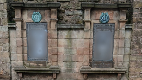 A war memorial containing graffiti that has been blurred for the viewer