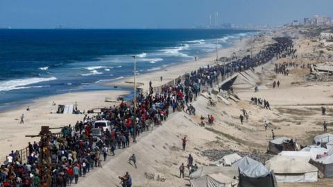 Palestinians, who were displaced to the southern part of Gaza at Israel's order during the war, walk along a road as they attempt to return to the north