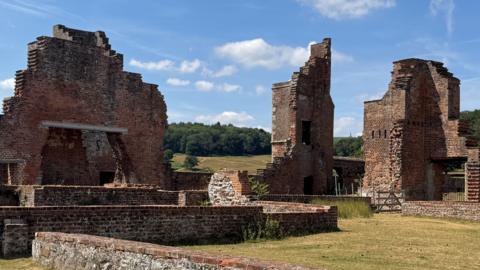 Ruins at Bradgate Park, with trees and blue sky in the background