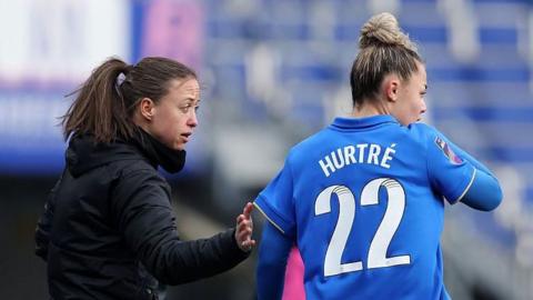 Birmingham City head coach Amy Merricks passes on some instructions to a player during a game