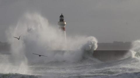 Big waves breaking against breakwater.
