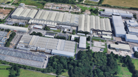 Google Earth image of the Capenhurst nuclear facility near Chester. It is a collection of industrial buildings surrounded by trees and fields. 