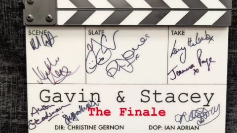 The signed clapperboard with twelve signatures on from the cast members. The clapperboard is white with 'Gavin & Stacey and 'The Finale' written on it and the signatures written around it in black permanent marker. 