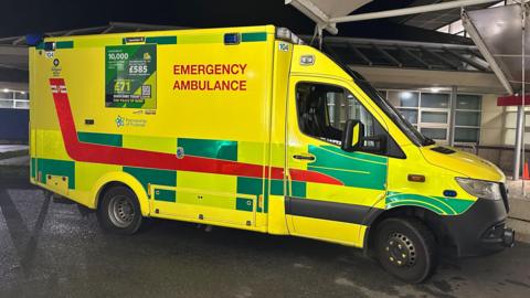 A picture of a large ambulance that is green and yellow in colour.
