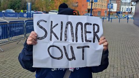 A Man Utd fan holds up a 'Skinner out' placard