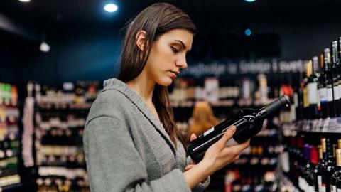 A woman buying wine