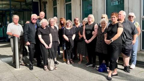 Campaigners against the closure of Northbrook swimming pool wearing black outside the Exeter City Council headquarters 