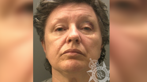 A custody image of Paula Attwood-Rees. She has a bruise on her eyelid and has dark hair 