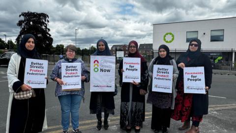 Campaigners with road safety sign on the road