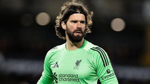 Liverpool goalkeeper Alisson, in a green match shirt, looks on during their FA Cup match against Wolves on 3 March