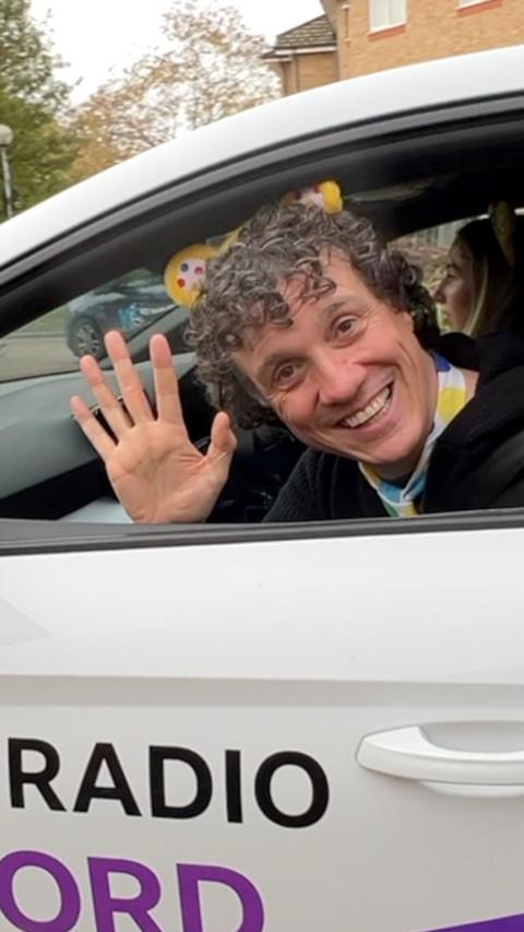 A man waves from a car window