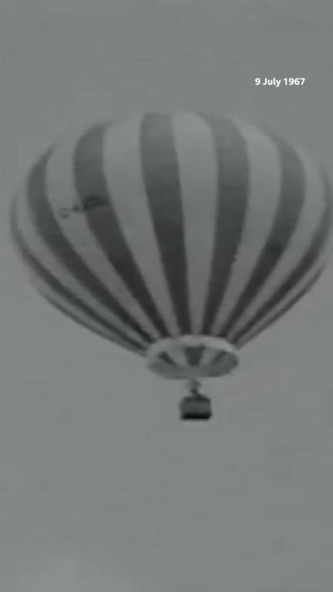 Black and white image of hot air balloon in the air