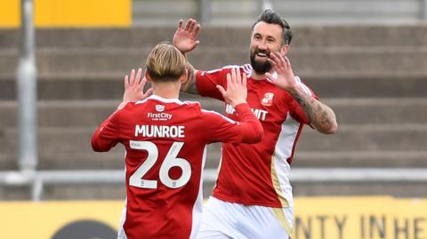 Ollie Palmer celebrates with Finley Munroe after putting Swindon in front at Newport County