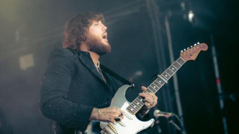 James Arthur playing a guitar