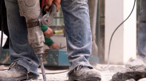 A generic shot of a builders' feet with a jackhammer drill 