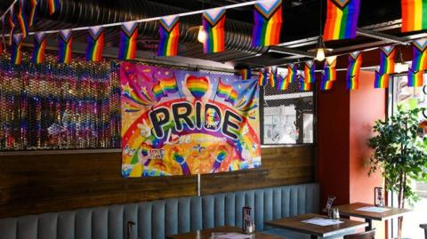 A banner displaying a rainbow and the word "Pride" which has been hung inside The Link