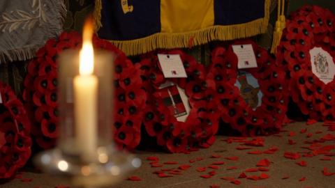 A close up of wreaths of poppies leaning up against the alter at Lincoln Cathedral.