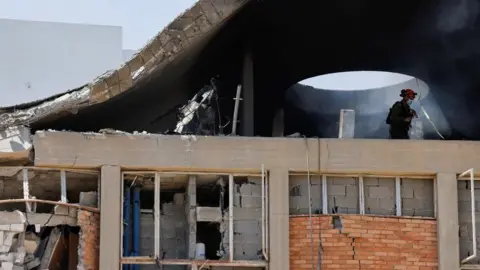 n Emergency worker inspects an impact site, following a missile strike from Iran on Israel, at Soroka Medical Center, in Be'er Sheva