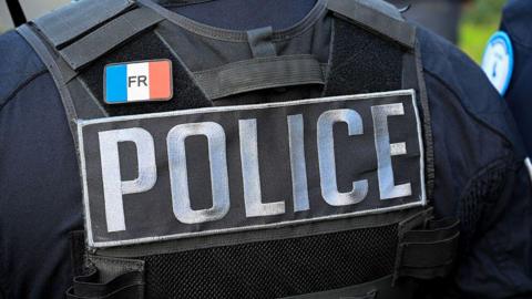 The bulletproof vest of an unidentified police officer is seen from behind in an archive image. The vest says 'Police' and has a badge bearing the French flag on.