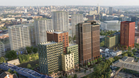 Numerous tower blocks are parallel and facing eachother on both sides of a river. A blue railway bridge is pictured, as well as Bristol's vast city scape in the background.