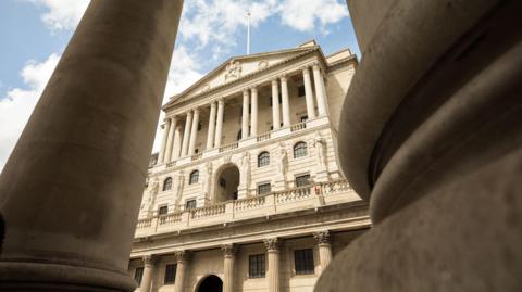 External shot of the Bank of England building taken from a low view with pillars either side in the foreground.