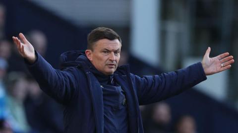 Paul Heckingbottom stands with his arms stretched out