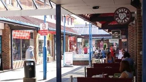 A town centre high street with a costa coffee on the right hand side.