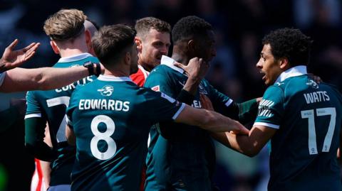 Plymouth Argyle and Exeter players confront one another