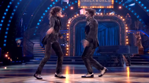 Dancers wear black suits