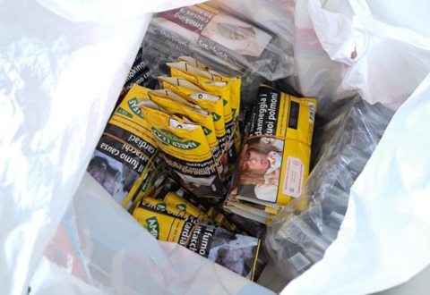 A white plastic bag containing dozens of small yellow packets 