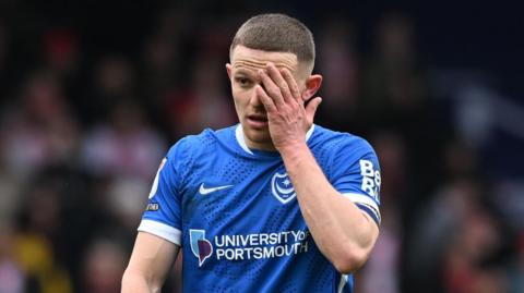 Colby Bishop covers his face during a Portsmouth match