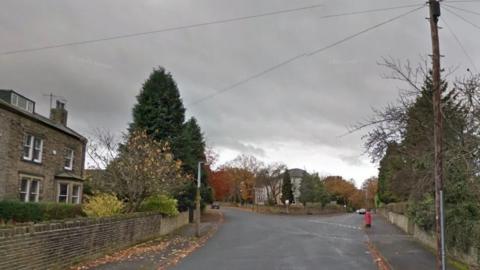 Nab Lane in Shipley. Pictured is a quiet-looking residential street with a wide road, trees and a post box.