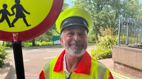 A smiling man with a beard wearing high-vis uniform