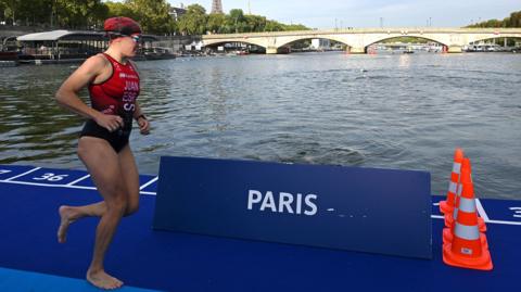 A triathlete runs next to the River Seine in Paris
