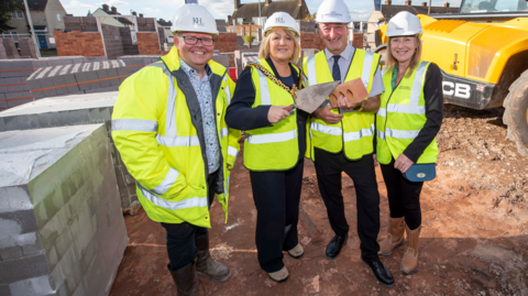 Partnership director at Keon tvs, Matt Beckley, Mayor of Wolverhampton, councillor Linda Leach, deputy leader Steve Evans and chief executive at Black Country Housing Group, Amanda Tomlinson are all on the building site in fluorescent jackets and hard hats with the mayor and councillor holding a brick and trowel